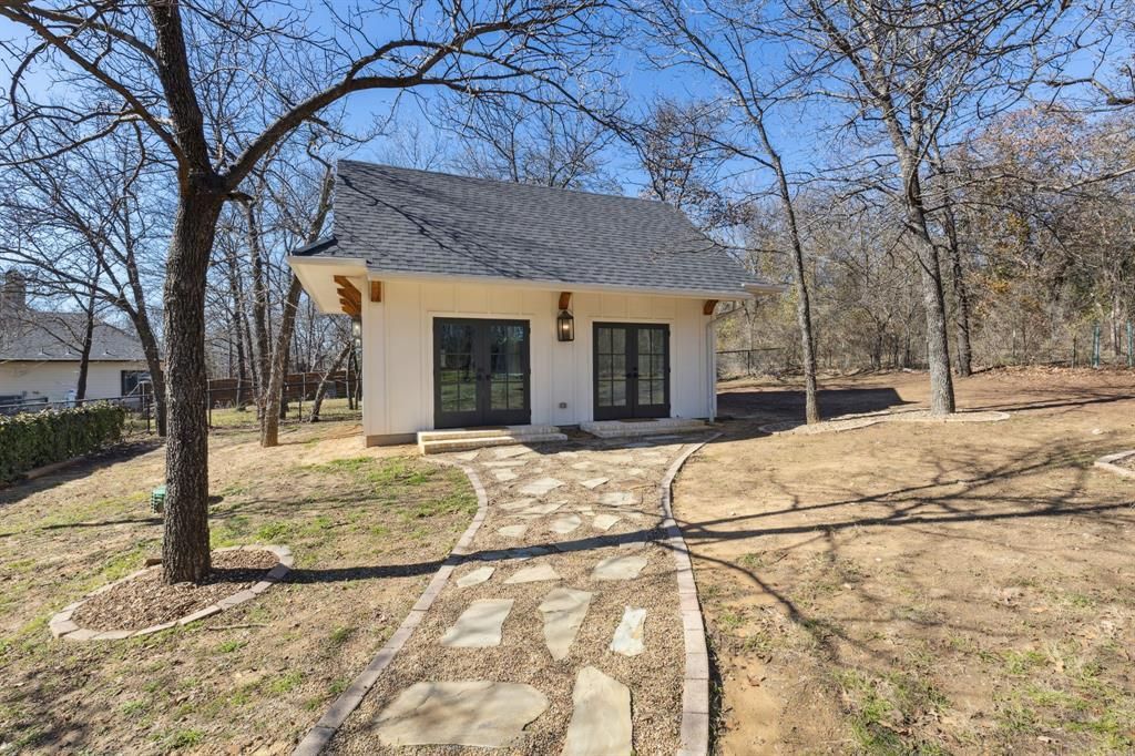 A large white house with a black roof and a driveway