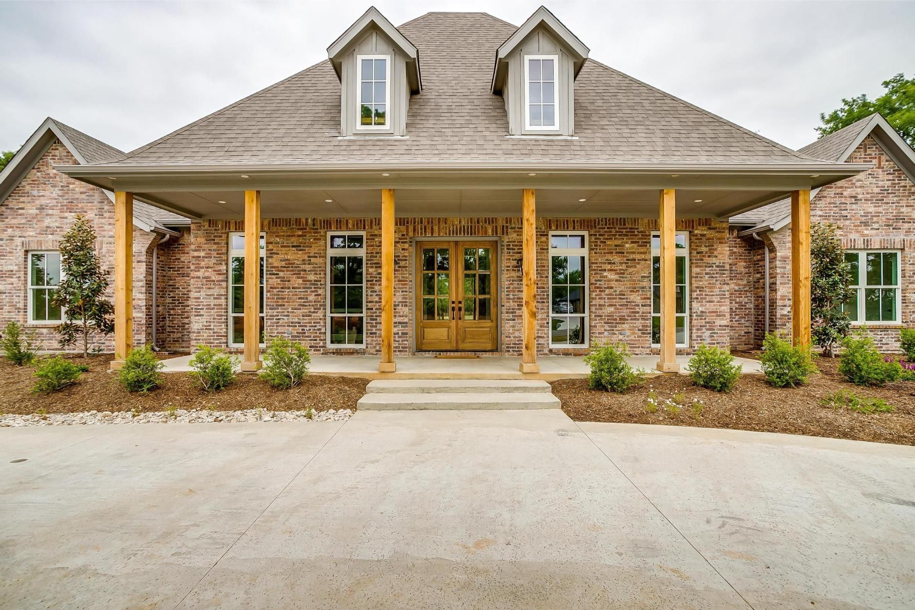 A large white house with a black roof and a driveway