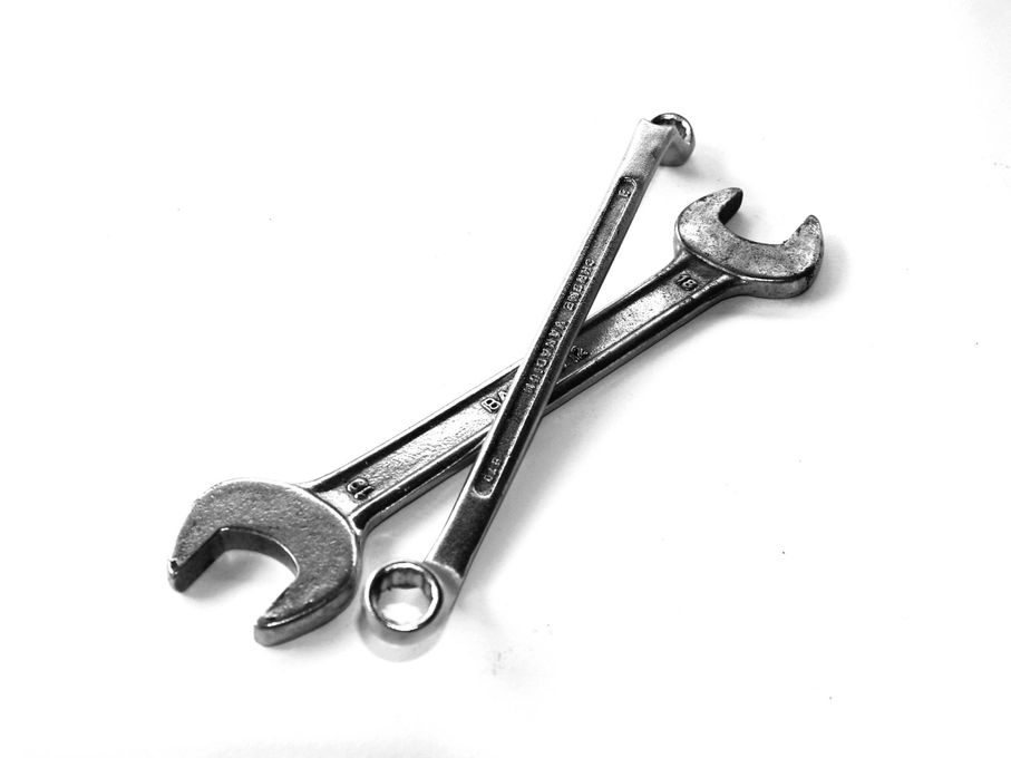 Two wrenches are crossed over each other on a white background