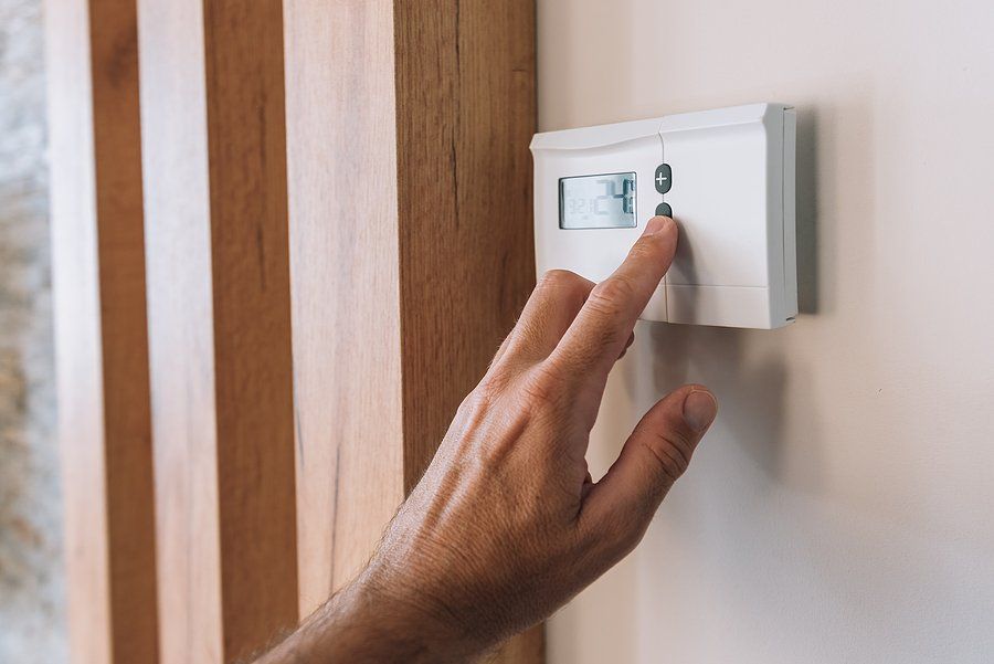 person controlling thermostat in home