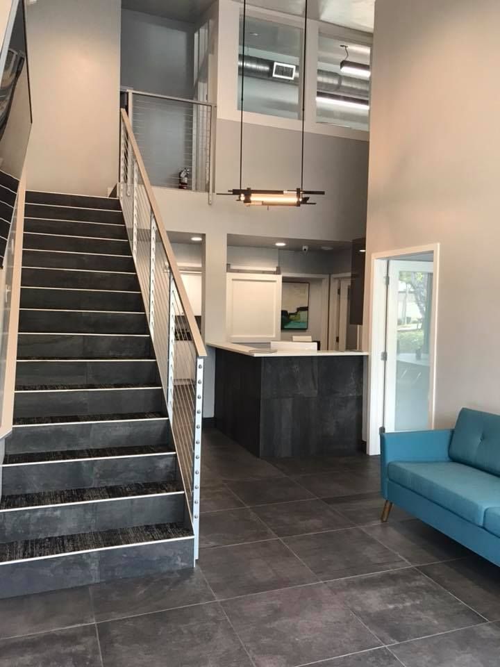 A living room with stairs and a blue couch