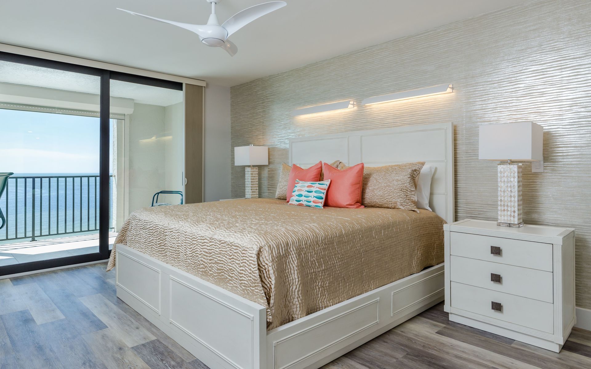 A bedroom with a king size bed , nightstand , and ceiling fan.