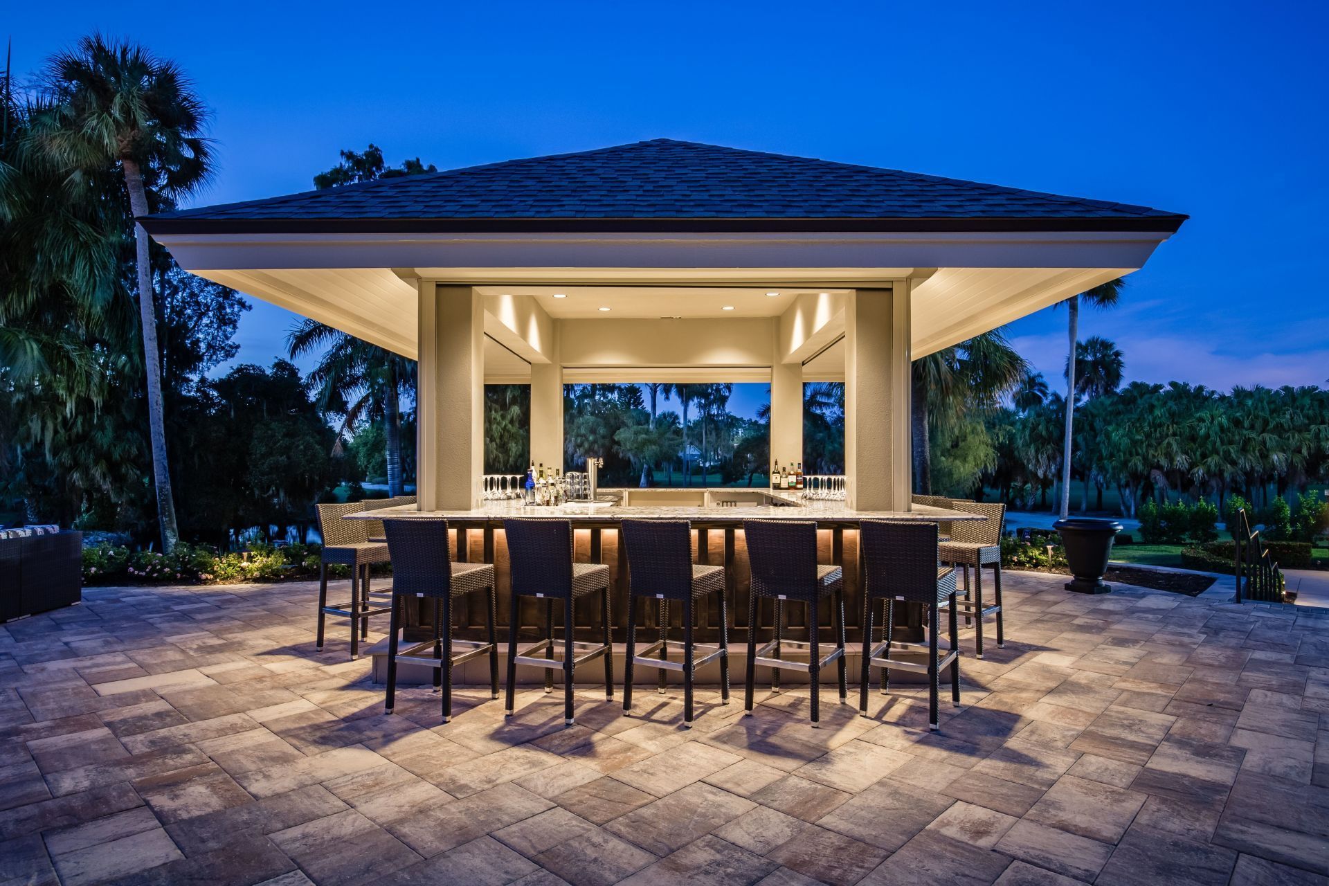 A large gazebo with a bar and chairs underneath it.