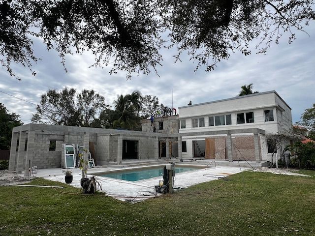 A large house under construction with a pool in the backyard