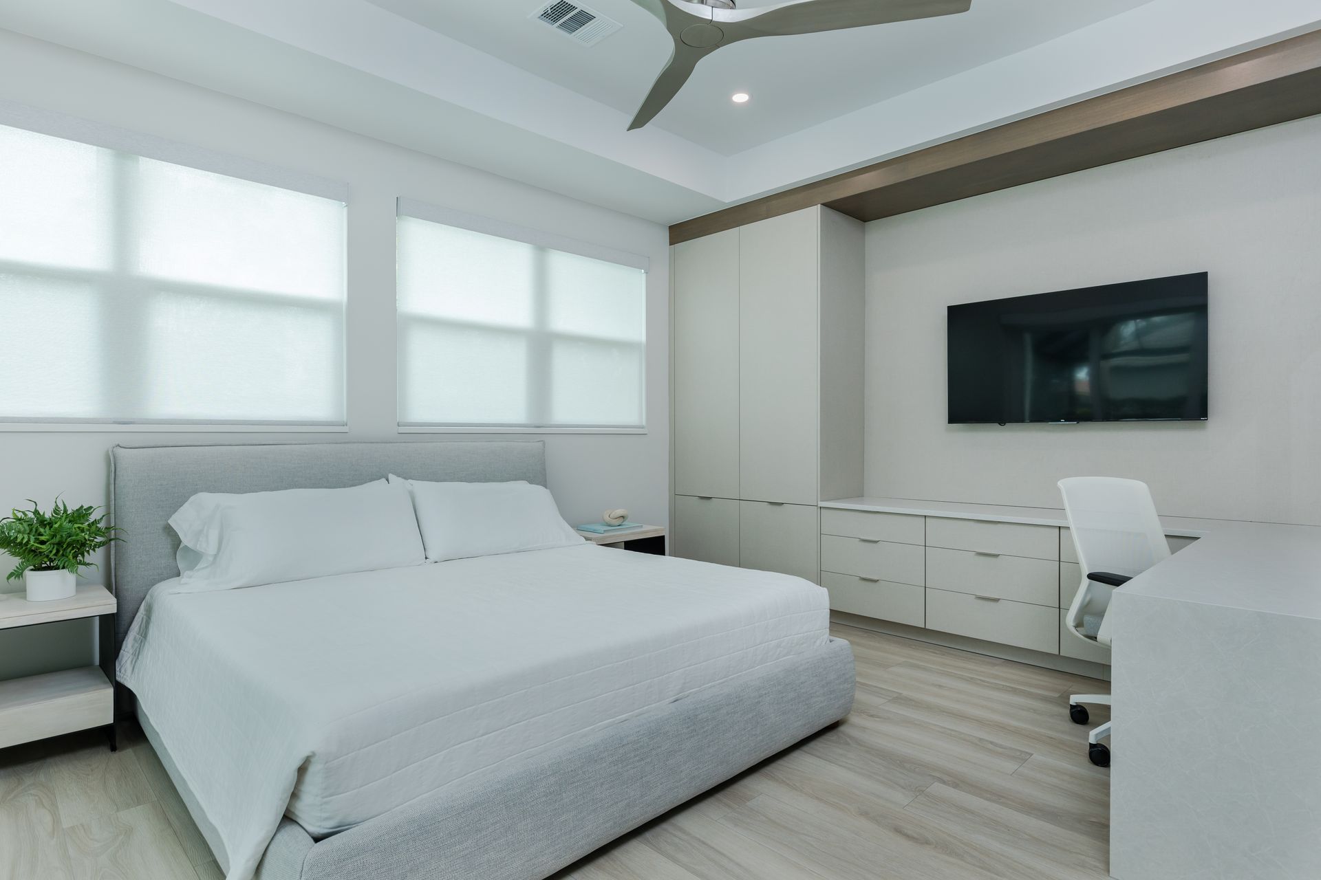 A bedroom with a large bed and a flat screen tv on the wall.