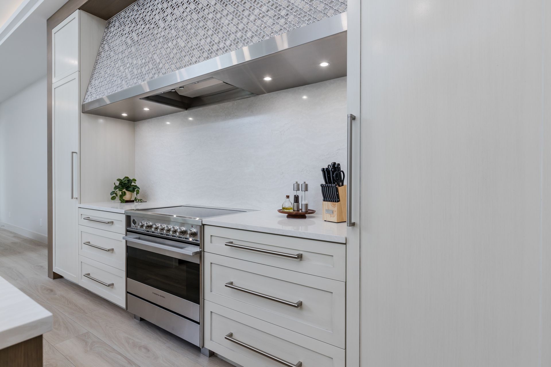 A kitchen with stainless steel appliances and white cabinets.