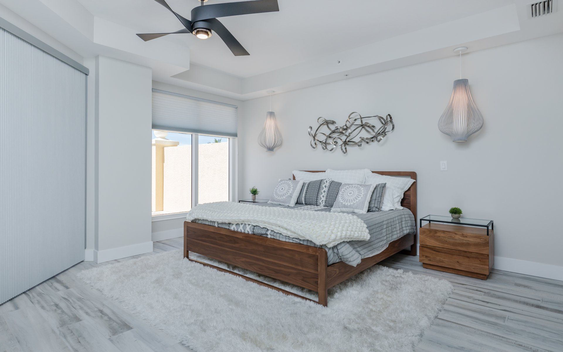 A bedroom with a large bed and a ceiling fan.