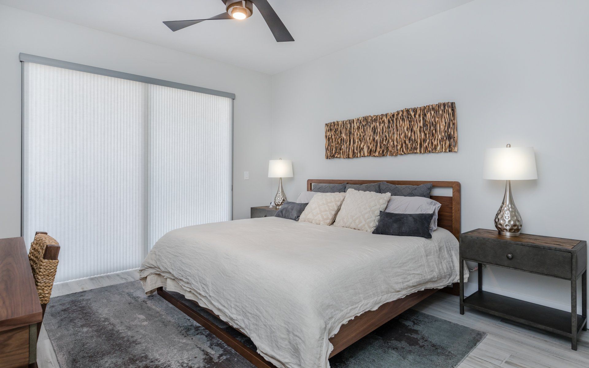 A bedroom with a large bed and a ceiling fan