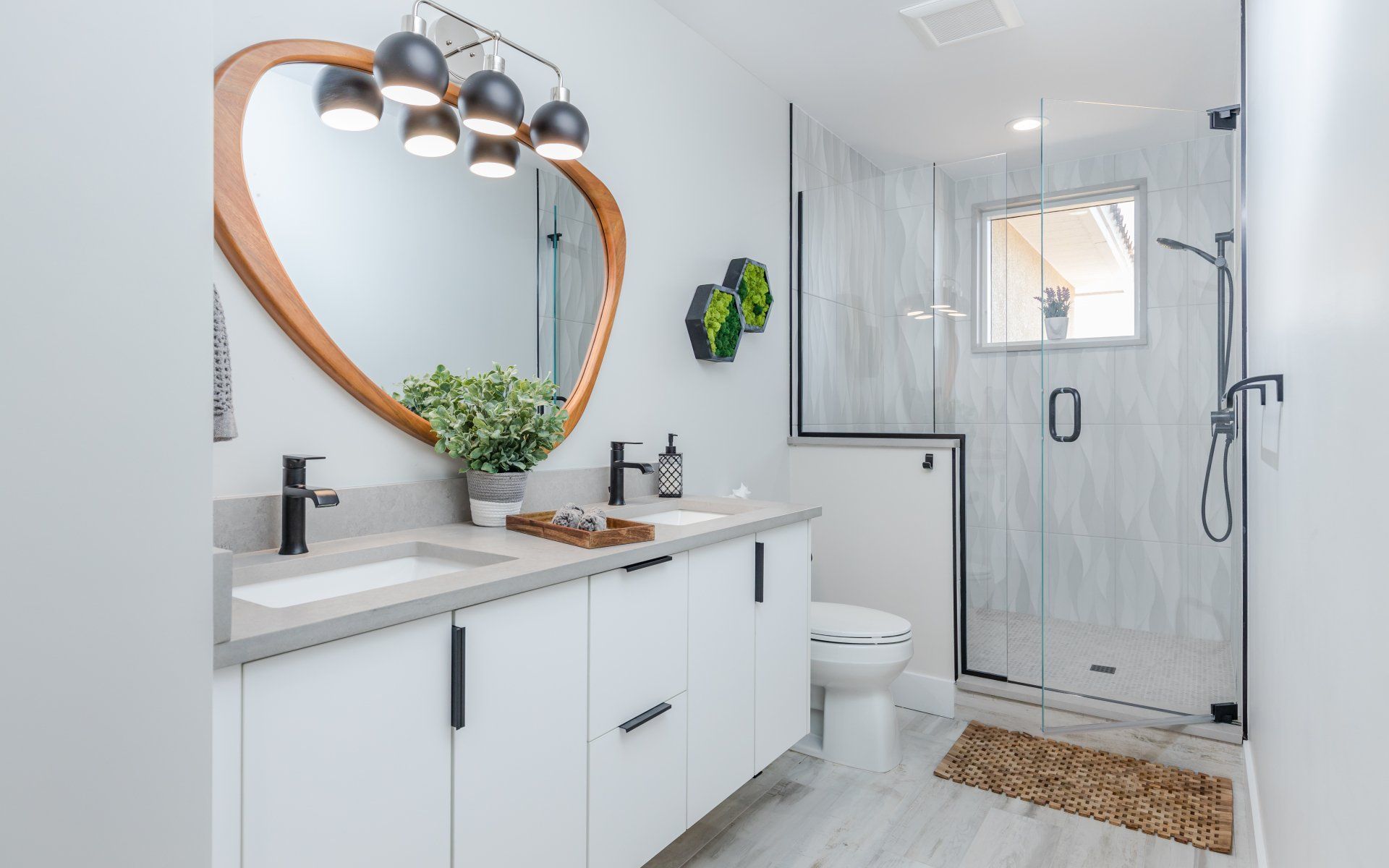 A bathroom with a toilet , sink , mirror and shower.
