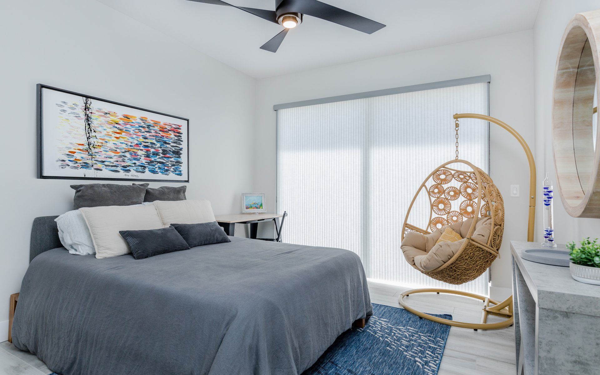 A bedroom with a large bed and a hanging chair.
