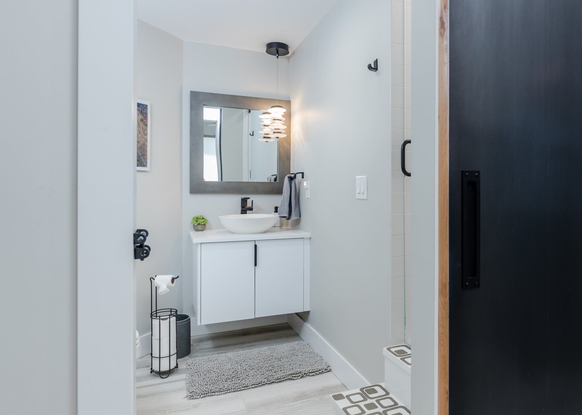 A bathroom with a sink , mirror and shower.