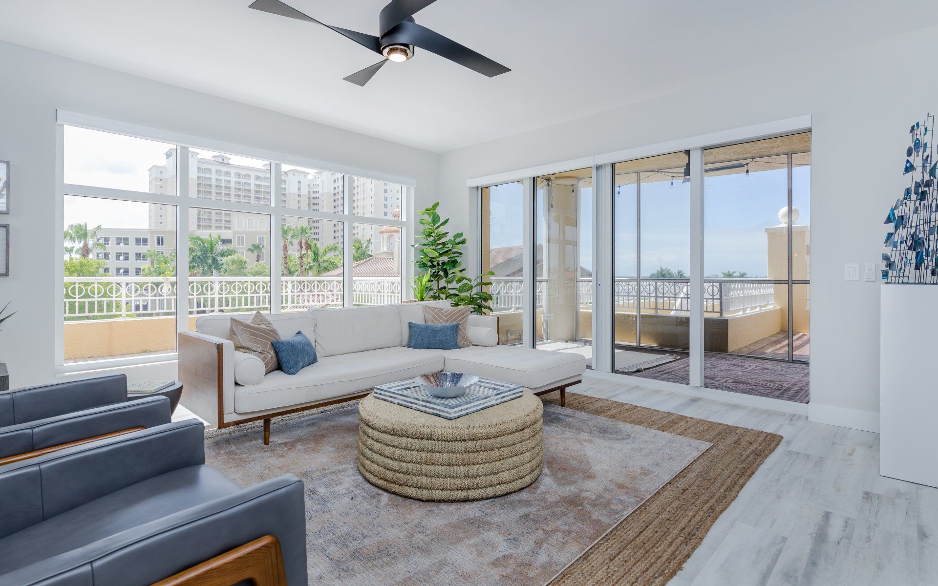 A living room with a couch , chairs , and a ceiling fan.