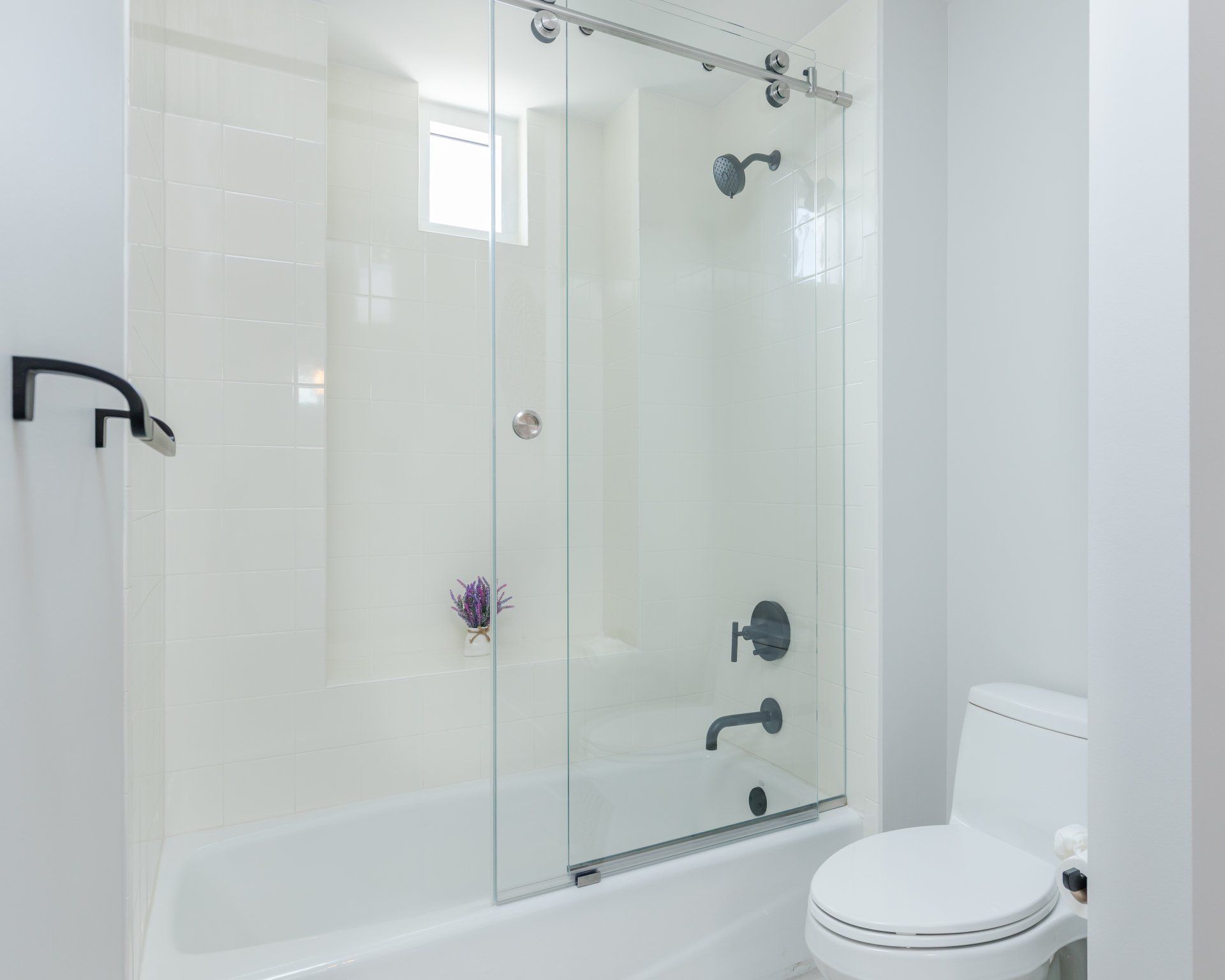 A bathroom with a tub , toilet , shower and sliding glass door.