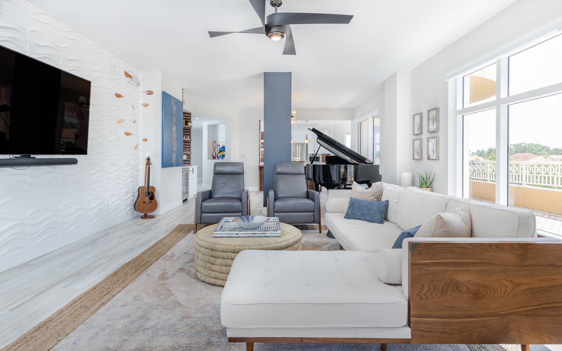 A living room with a couch , chairs , a piano and a television.