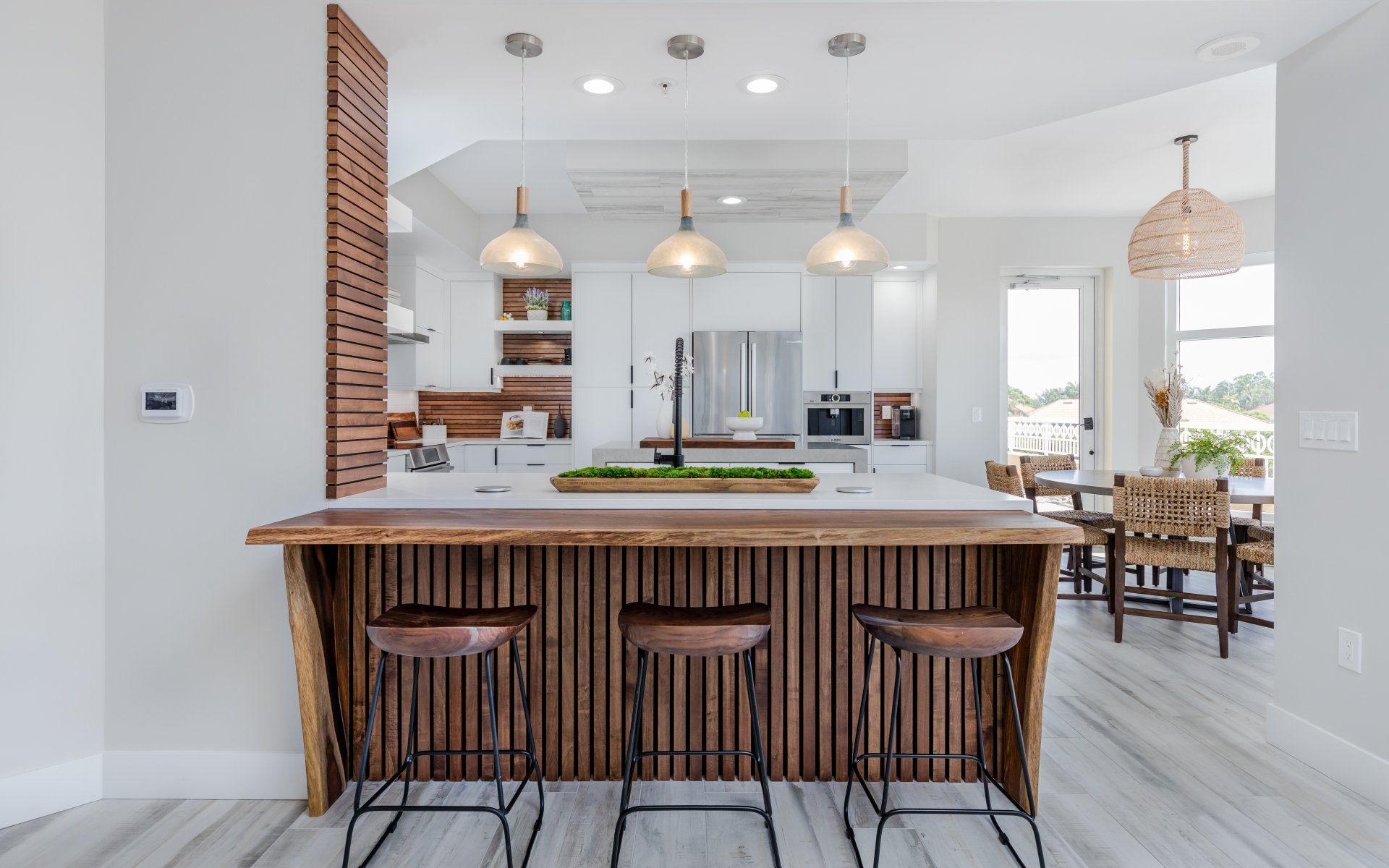 A kitchen with a wooden island and three stools.