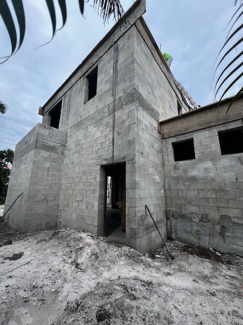 A large brick building is being built in the middle of a dirt field.