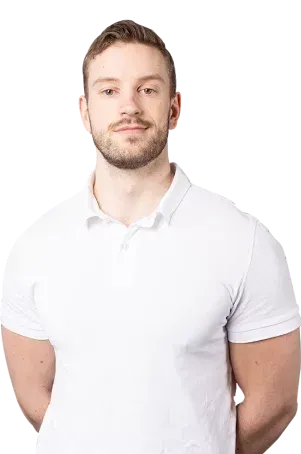 Mann iført hvit poloskjorte med armene bak ryggen og ser på betrakteren.