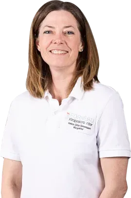 Kvinne i hvit skjorte smiler, tekst på skjorte, skulderlangt brunt hår, lys bakgrunn.