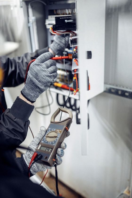 Engineer working on checking and maintenance equipment at wiring on PLC cabinet