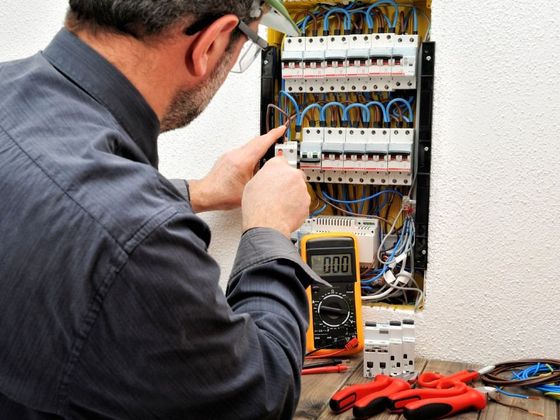 Technical electrician fixing the cable into the terminal of a circuit