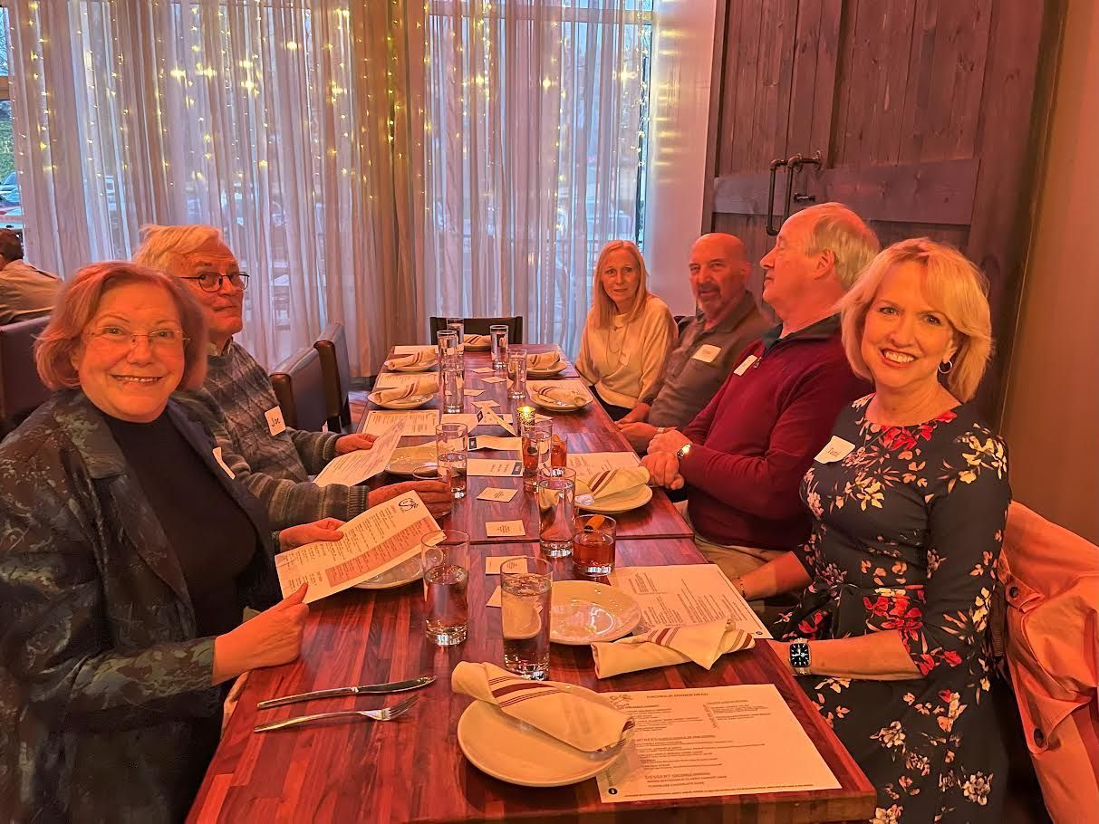 A group of people are sitting at a long table in a restaurant.