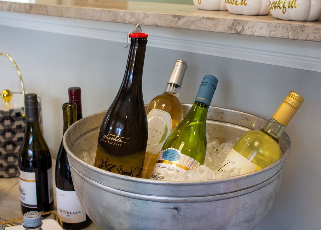 A metal bucket filled with ice and wine bottles on a table.