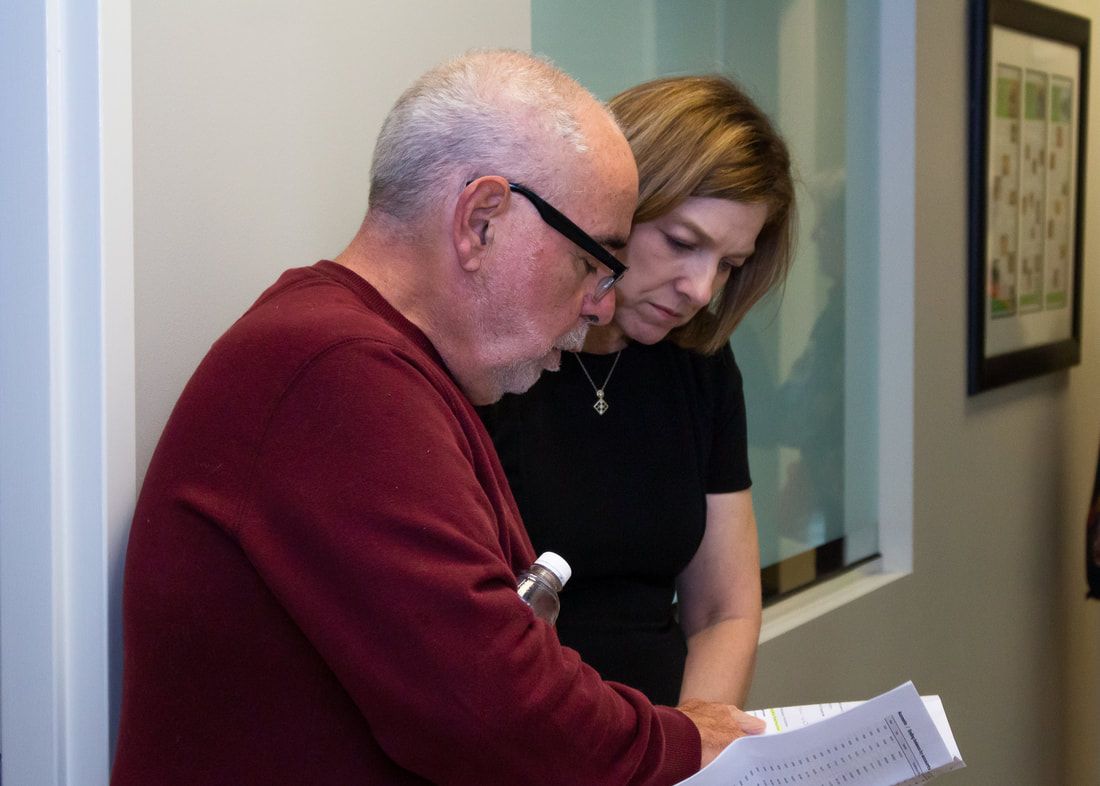 A man and a woman are looking at a piece of paper.