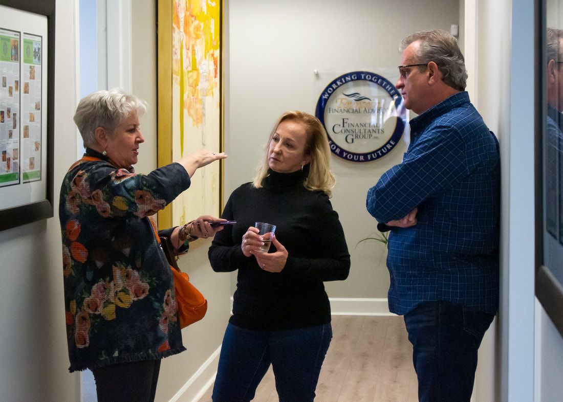 A group of people are standing in a hallway talking to each other