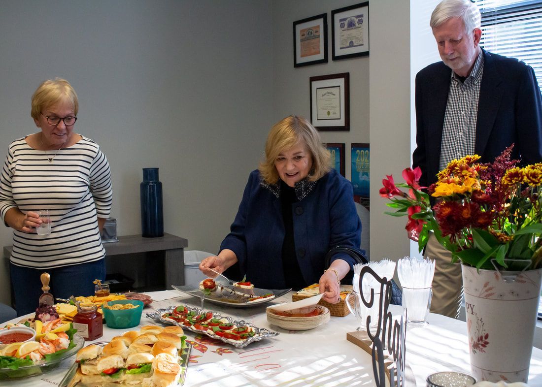 A group of people are sitting around a table eating food.