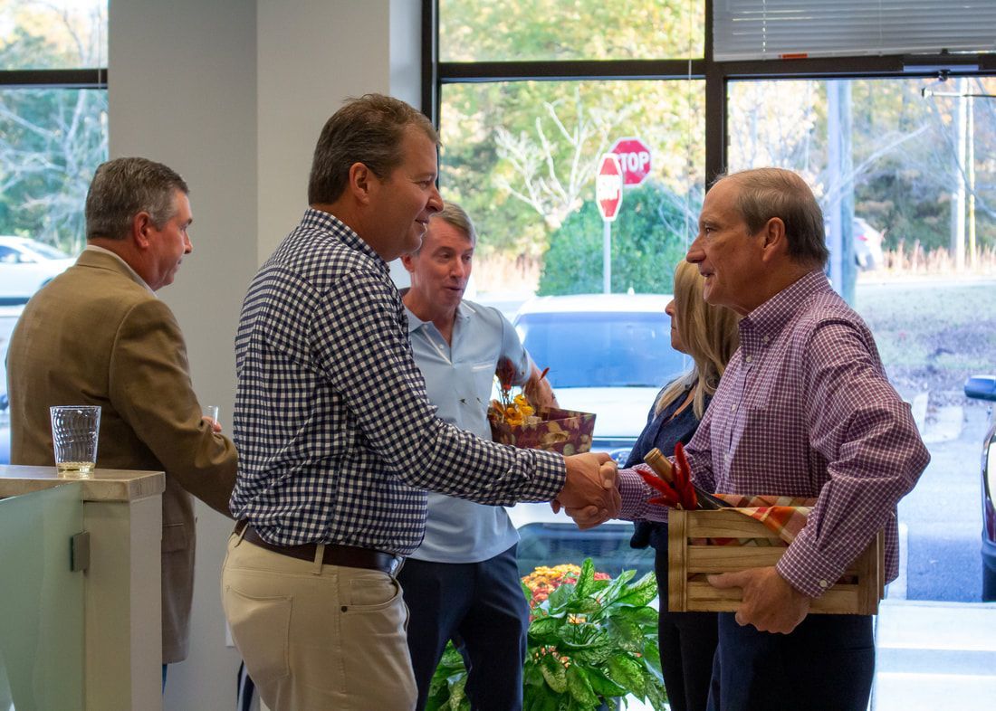 A group of men are shaking hands in a room with a stop sign in the background.