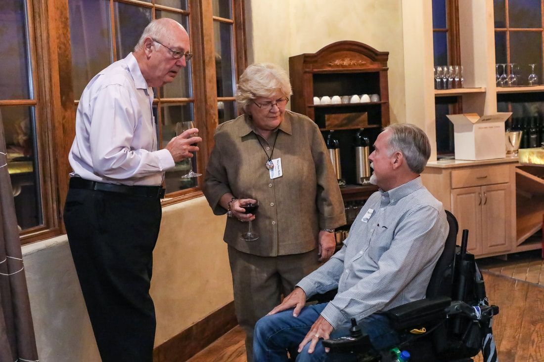 A man in a wheelchair is talking to two other people