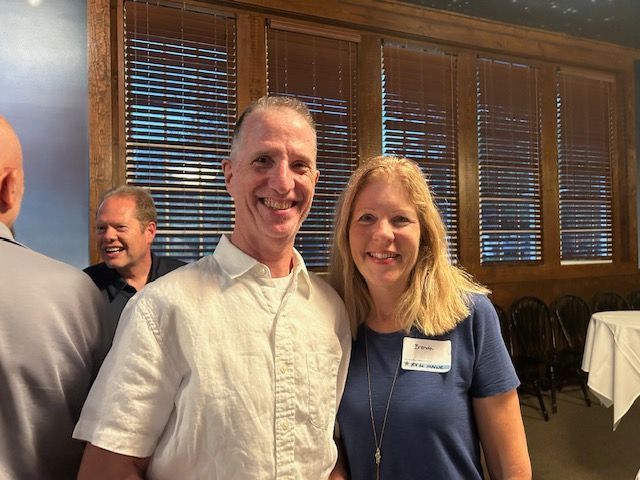 A man and a woman are posing for a picture in a room.