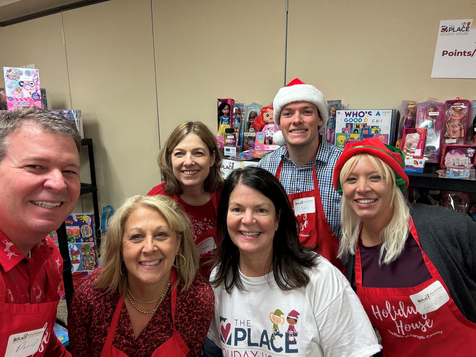 A group of people are posing for a picture in a room.
