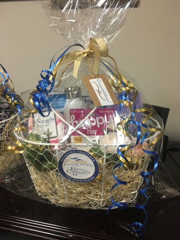 A gift basket wrapped in plastic sitting on top of a table.