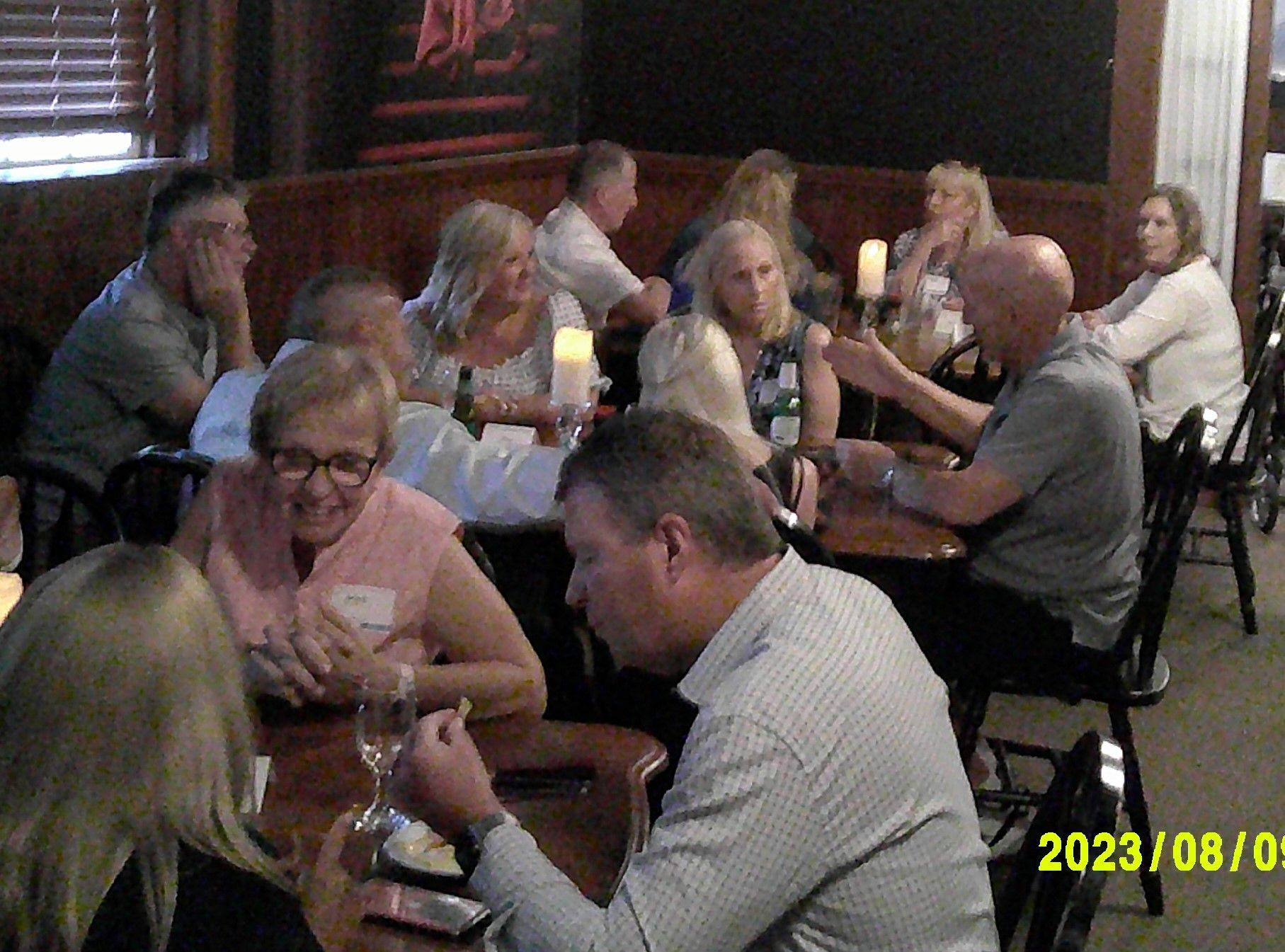 A group of people are sitting at tables in a restaurant.