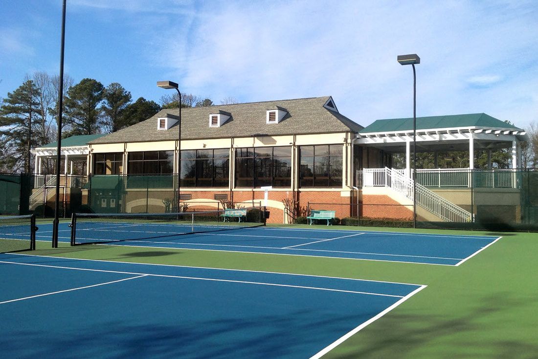 A tennis court with a building in the background