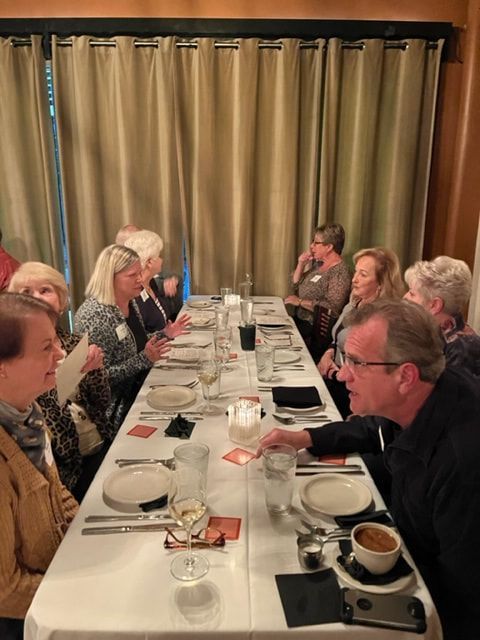 A group of people are sitting at a long table in a restaurant.