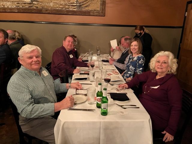 A group of people are sitting at a long table in a restaurant