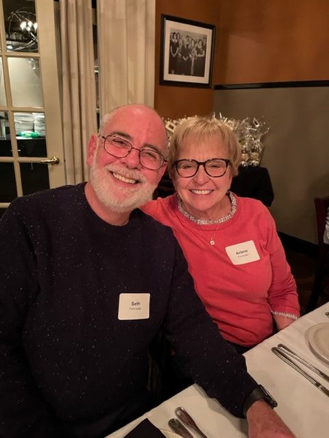 A man and a woman are posing for a picture at a table