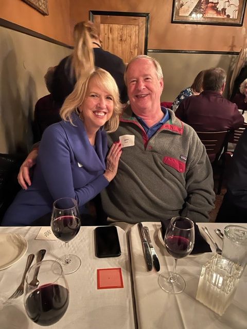 A man and a woman are sitting at a table with wine glasses