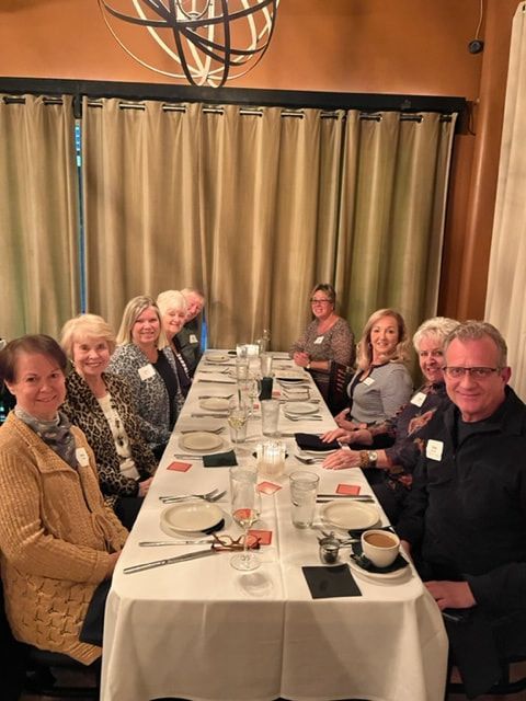 A group of people are sitting at a long table in a restaurant.