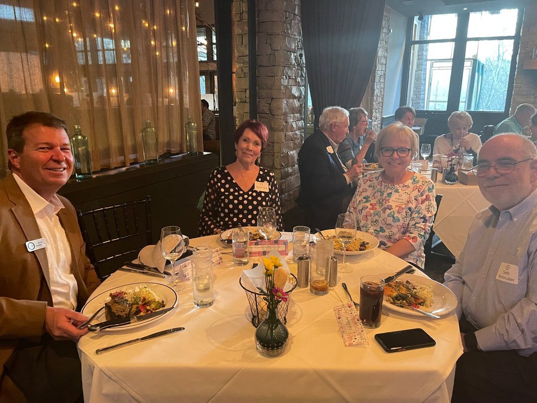 A group of people are sitting at a table with plates of food.