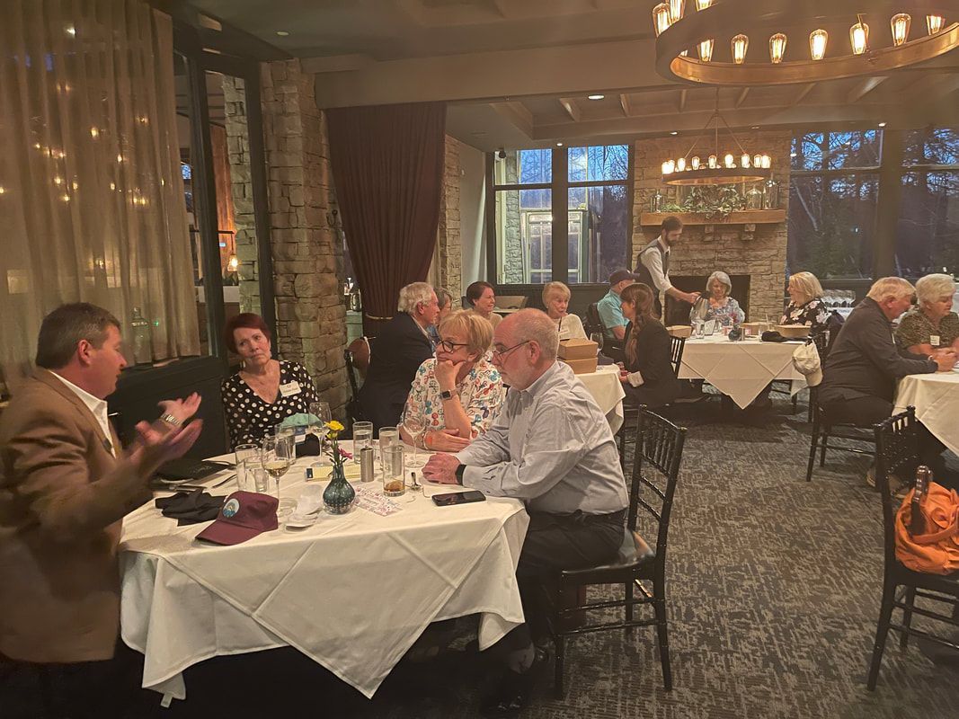 A group of people are sitting at tables in a restaurant.