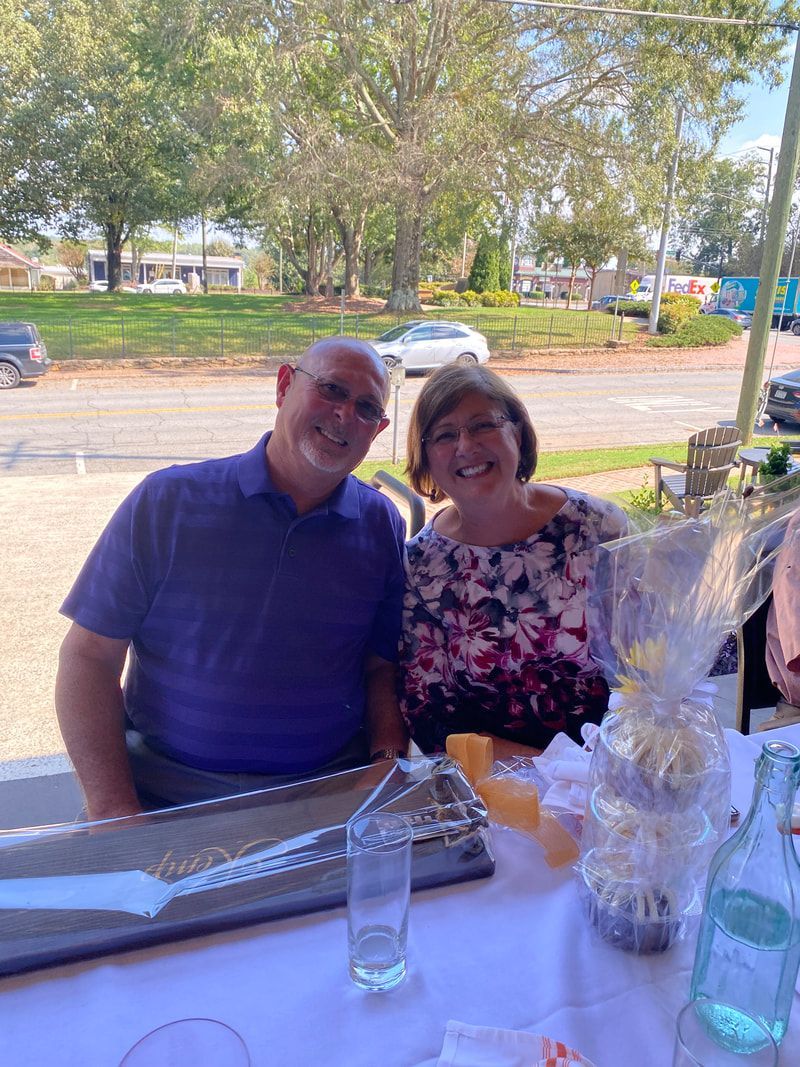 A man and a woman are posing for a picture at a table.