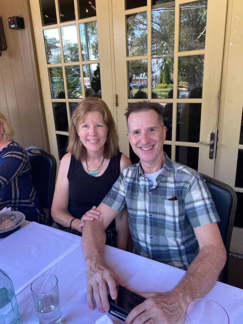 A man and a woman are sitting at a table smiling