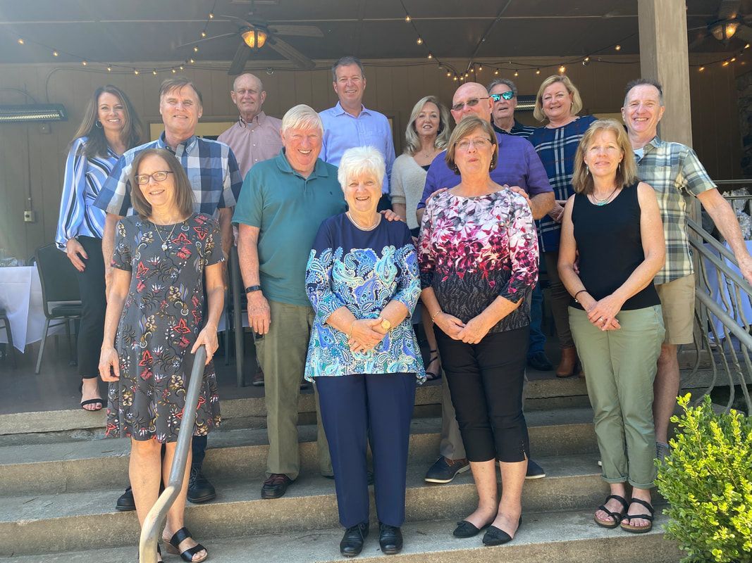 A group of people are posing for a picture on the steps of a building.