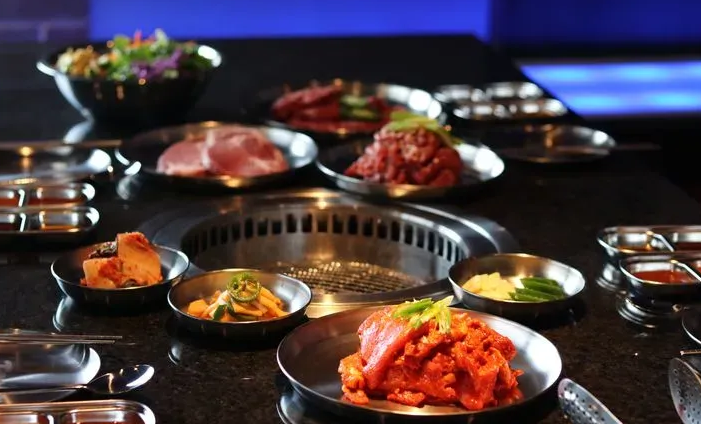 A table topped with plates of food including meat and vegetables