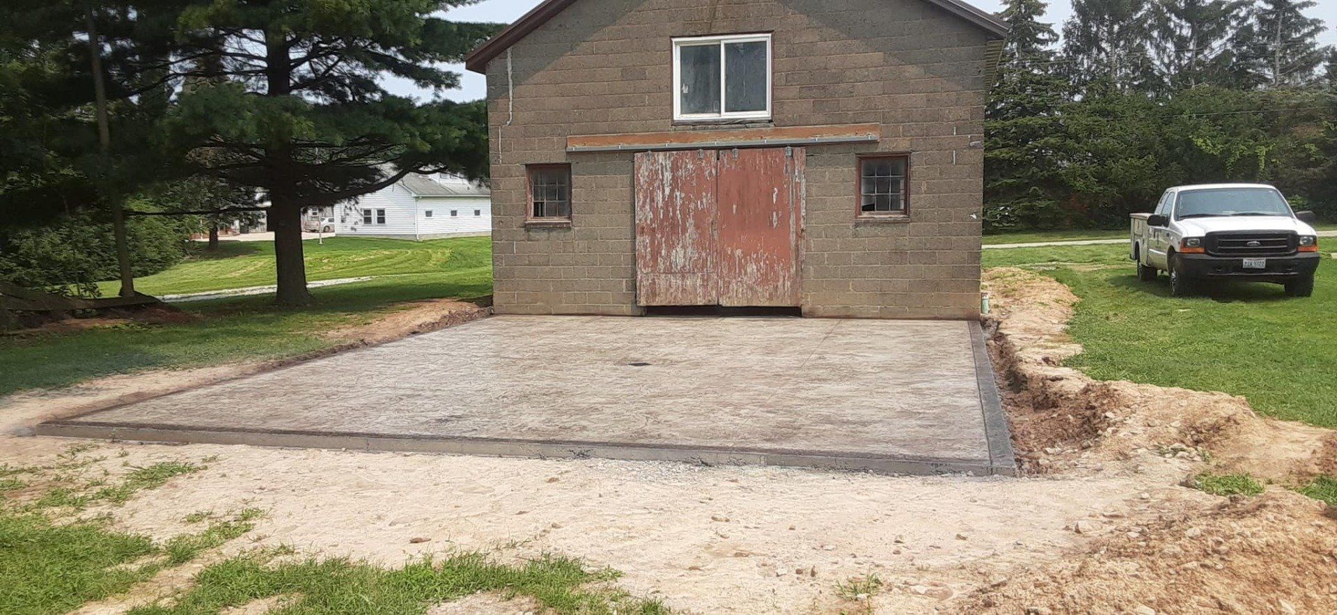 A white truck is parked in front of a brick building.