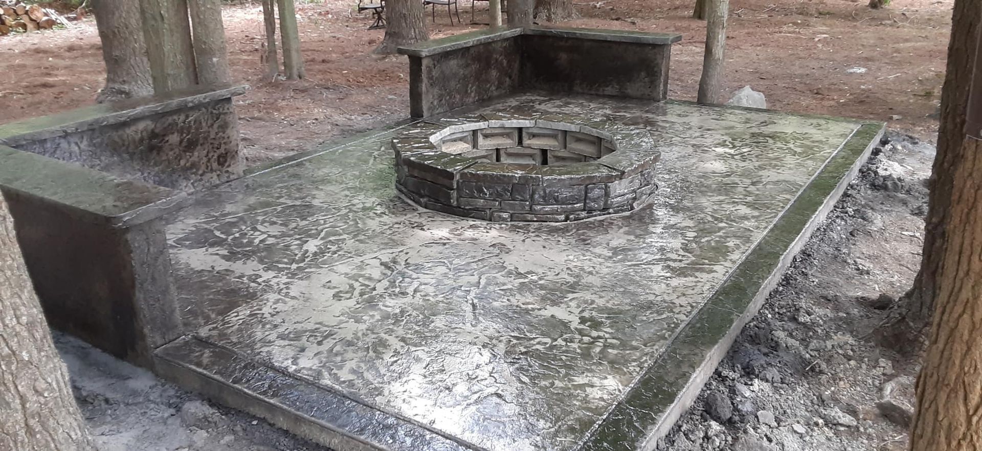 There is a fire pit in the middle of the woods.