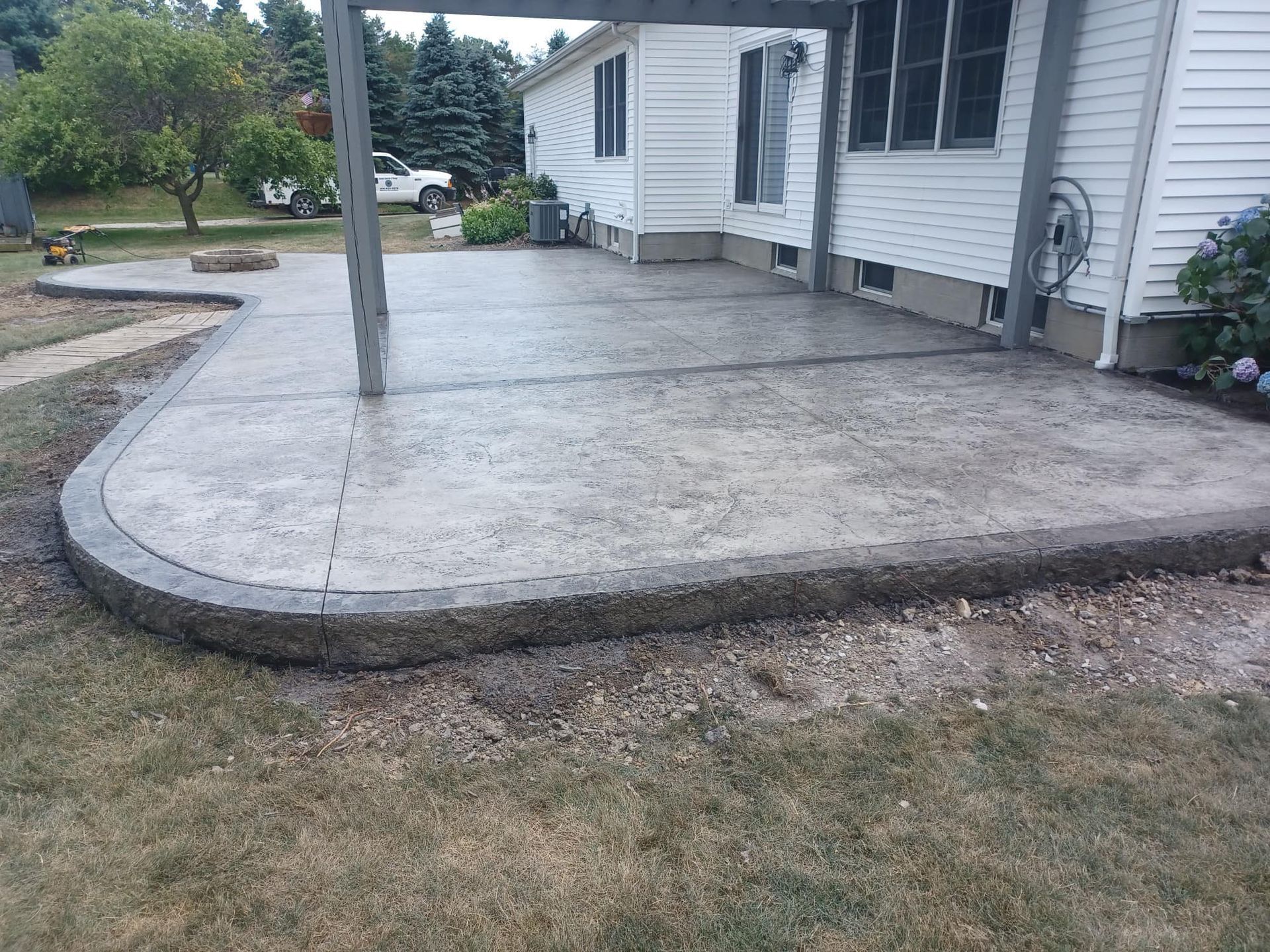A concrete patio is being built in front of a house.